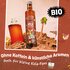 Cola syrup bottle in beach scene with drink, palm tree and text “ORGANIC” and “without caffeine & artificial flavors also for young cola fans”