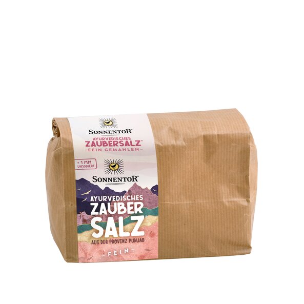 Foto einer Großpackung ayurvedischen Zaubersalz. Darauf zu sehen sind bunte Berge. Durch ein kleines Fenster kann man das rosa Salz sehen.