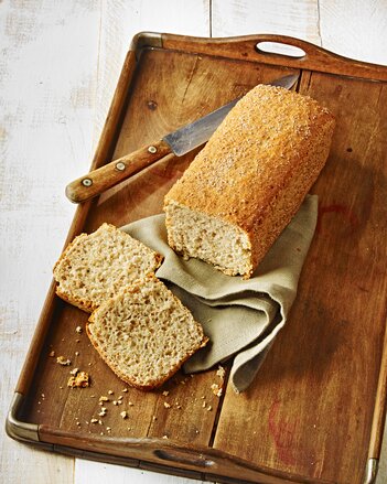 Auf dem Foto sieht man ein Holztablett auf dem ein angeschnittenes Dinkel-Leichtbrot zu sehen ist. | © SONNENTOR