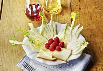 Auf dem Foto ist auf einem Teller marinierter Fenchel zu sehen. Darauf sieht man Ziegenkäsescheiben und Himbeeren. | © SONNENTOR