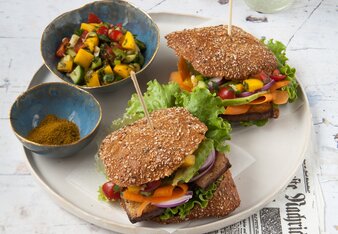 Auf dem Foto sieht man zwei Burger mit Tofu. Daneben sieht man eine Schale mit buntem Gemüse. | © SONNENTOR