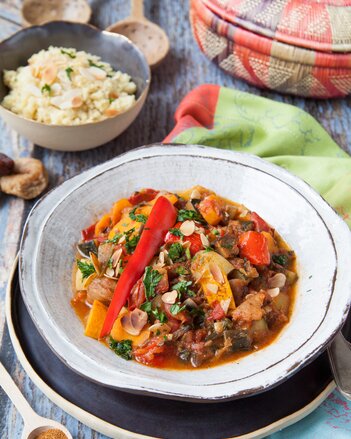 Auf dem Foto ist ein Teller mit Habeshas vegetarischer Tajine. Dahinter ist eine Schale mit Couscous zu sehen. | © SONNENTOR