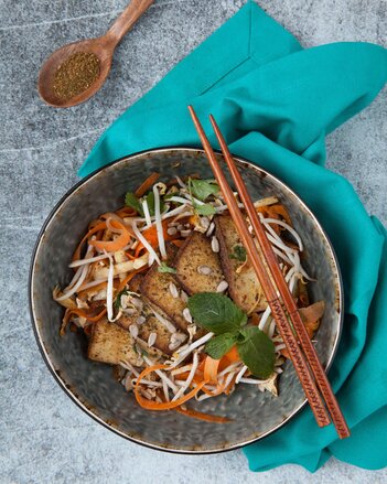 Auf dem Foto sieht man eine Schüssel mit Tofu Salat und Sprossen. Darauf sieht man zwei Stäbchen. | © SONNENTOR