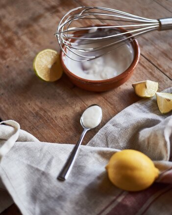 Auf dem Foto ist eine Schale mit Mayonnaise zu sehen. Darauf liegt ein Schneebesen. Daneben sind ein Löffel und Zitronenstücke zu sehen. | © SONNENTOR