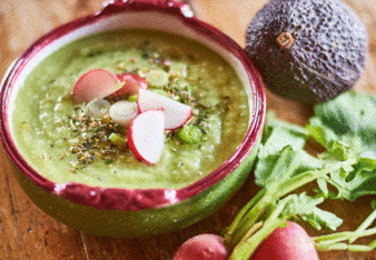 Auf dem Foto ist ein Teller mit Gurken-Avocado Suppe zu sehen. Daneben liegen Radieschen und eine Avocado. | © SONNENTOR