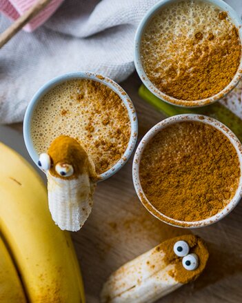 Au dem Foto sieht man drei Tassen mit Bananen-Smoothie. Sie sind mit Kurkuma bestreut. | © SONNENTOR