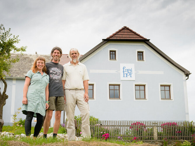 Auf dem Foto sieht man drei Personen vor dem Freihof stehen. | © SONNENTOR