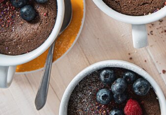 Auf dem Foto sieht man drei Tassenkuchen die mit Beeren und Alles Liebe Gewürzblüten garniert sind. | © SONNENTOR