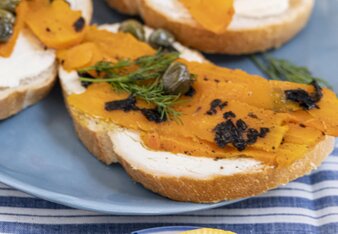 Auf dem Foto ist Brot mit Karottenlachs darauf zu sehen. Davor sieht man ein Teller mit Zitronenscheiben. | © SONNENTOR