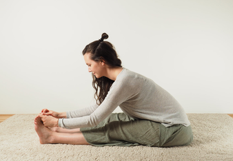 Auf dem Foto ist eine Frau beim Yoga zu sehen. Sie führt die Vorbeuge aus. | © SONNENTOR